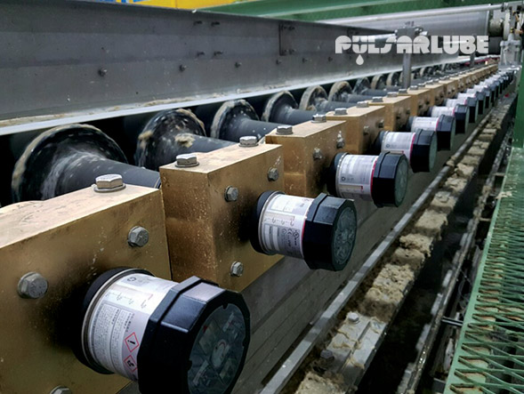 Pulsarlube automatic lubricators installed along multiple lubrication points on industrial roller equipment