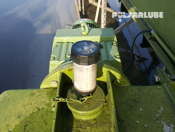 Pulsarlube automatic grease lubricator mounted on a green industrial gearbox