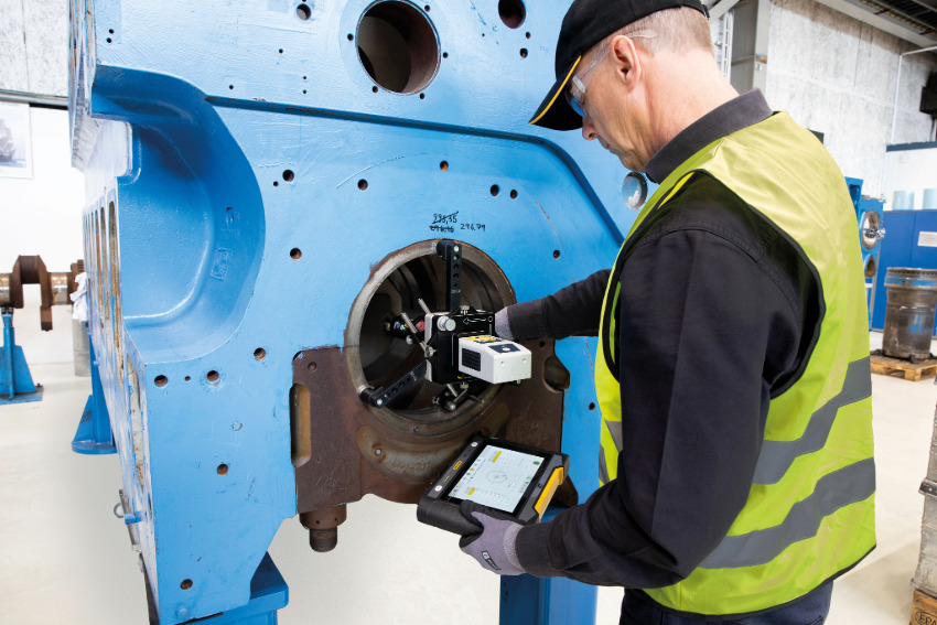 A technician setting up the Easy-Laser XT950 laser bore alignment system on an engine bearing journal